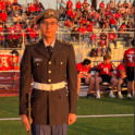 JC standing on a football field during a game in JROTC regalia