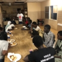 A group of Senegalese sit around a large table and break fast