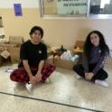 Cynthia and Rafi sitting on the floor in front of the boxes