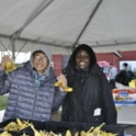 Abimanyu smiling with a friend at a volunteer event, holding up bananas