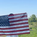 Layal Holding Up An American Flag With Writing On It