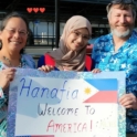 Hanafia stands with her host family with a sign that says, "Hanifa welcome to America"