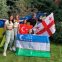 YES student, Imge, standing with five other students holding up country flags.