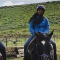 YES student, Seema, riding a horse with two other people next to her on horses.